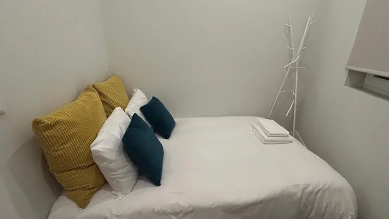 Quarto com cama de casal e almofadas amarelas e azuis