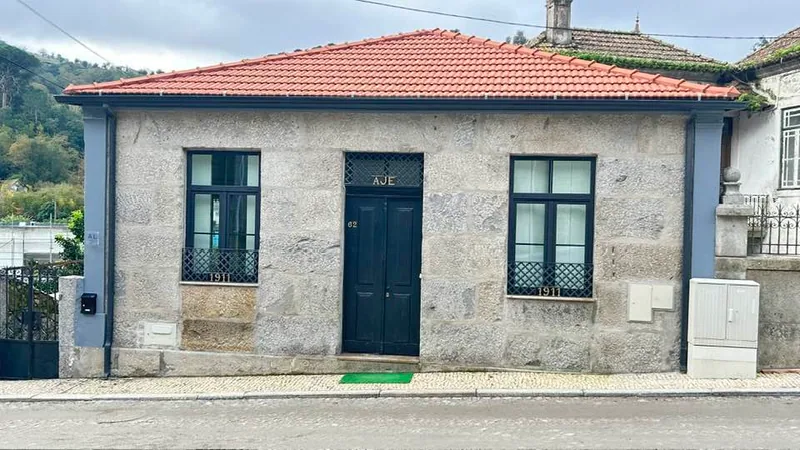 A fachada de granito e a porta azul do Chalé Caldas de Aregos